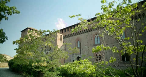 Camera Pans and Pushes Left Displaying Enormous Castle With Foreground Trees Stock Footage 202670087
