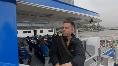 Camera pans around man on a river Thames passenger boat 動画素材 90201413