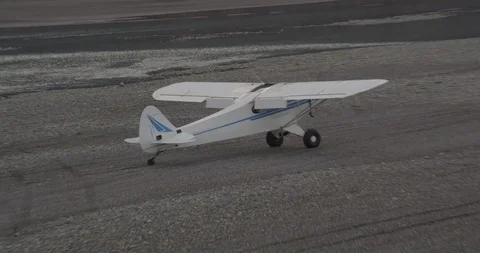 Camera pans around small plane on gray land, helicopter shot, drone Video stock 107888085