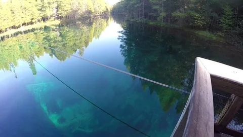 Camera pans from boat to reflective spring Stock Footage 81765216