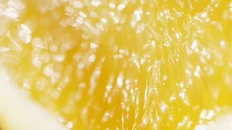 Camera pans in close up over a slice of orange glistening in the sunlight 库存影片 81645795