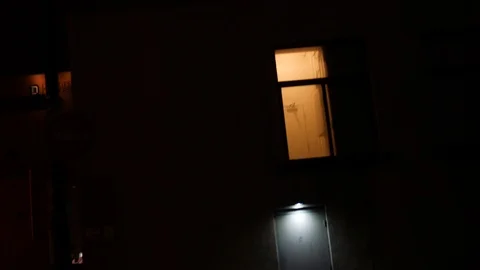 Camera pans to dimly lit suspicious doorway in city at night near alley Video stock 86001642