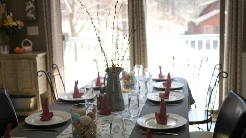 Camera pans down decorative dining room table set for an Easter dinner Stock Footage 88064718