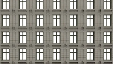 The camera pans down the front of a building with illuminated windows from top Video stock 148047596