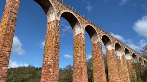 Camera pans down from viaduct to river on sunny Spring day 스톡 동영상 152761161