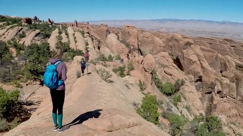 Camera pans off female overlooking rock formations at Arches NP Video stock 79577045
