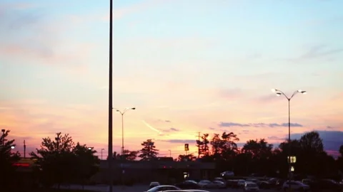 Camera pans up to glowing street light in parking lot near dusk Stock Footage 76265273