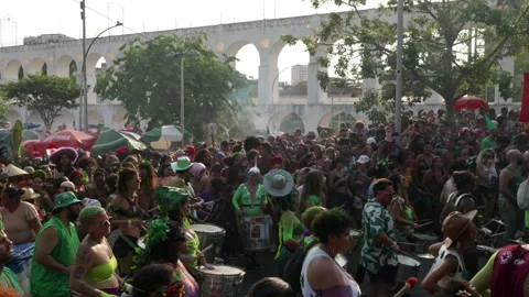 Camera pans left across a crowded Rio Carnaval parade with musicians near Arcos Stock Footage 336287842