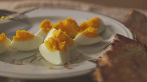 Camera pans to left over breakfast plate with hard boiled egg and toast Stock Footage 136655283