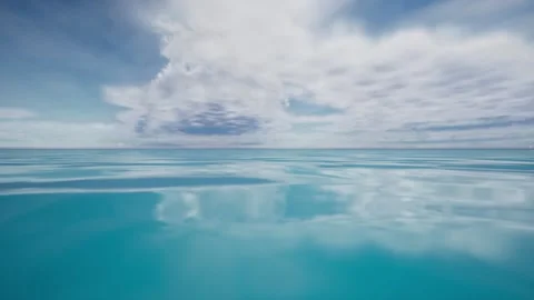 The camera pans from left to right over the surface of blue water, which merges Stock Footage 161054590