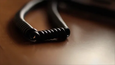 Camera pans by old telephone cord from landline phone Vidéo 74253793