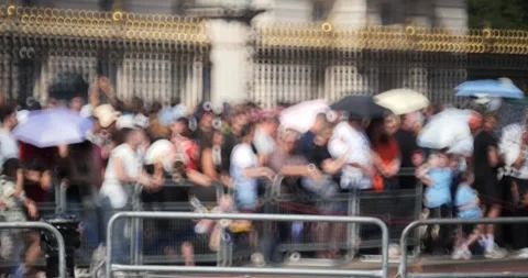 Camera pans over a blurred crowd gathered behind metal security barriers Stock Footage 345124023