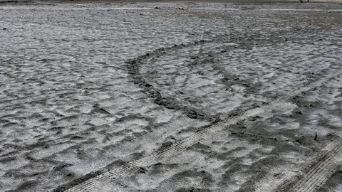 Camera pans over car path on crystal salt rock salty beach shore Stock Footage 70355383