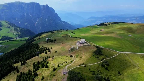 Camera pans over lush green mountain with ski lift and buildings Stock Footage 284980949