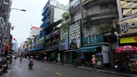 Camera pans over mopeds on Bui Vien Walking Street, capturing Ho Chi Minh City's Stock Footage 305449414