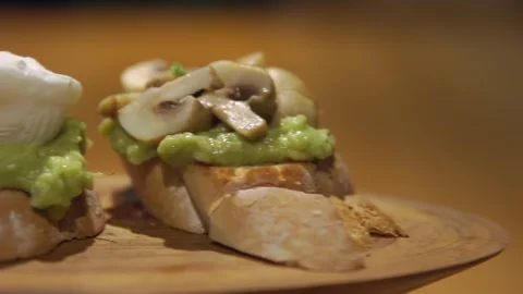 The camera pans over a perfect breakfast with bruschettas with avocado, cherry Stockbeeldmateriaal 256143519