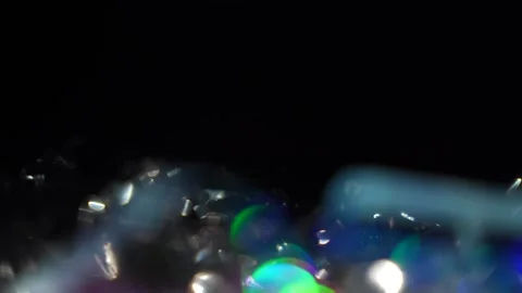 The camera pans over the purple, white, and bright colors of the bokeh at the bo Stock Footage 315318583