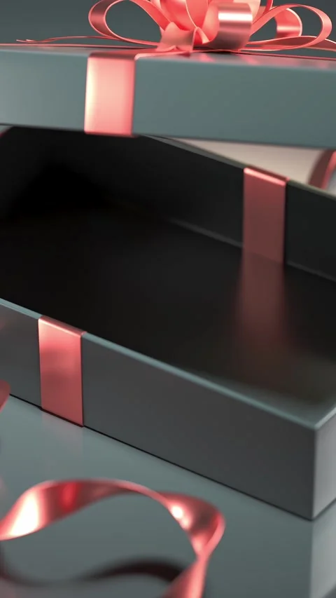 The camera pans over a shiny gift box with a detailed bow, set on a reflect.. Stock Footage 294325114