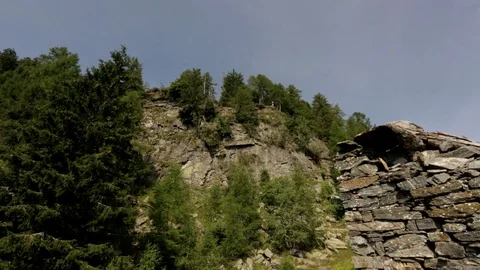Camera pans from rock face to remains of crumbled house. Stock Footage 86756669