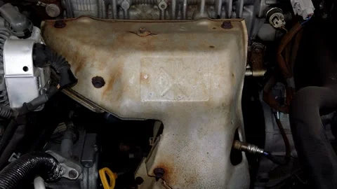 Camera pans slowly across a rusty exhaust manifold heat shield Stock Footage 335834244