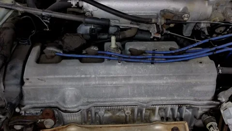 Camera pans slowly over a dusty silver car engine bay Stock Footage 335834363