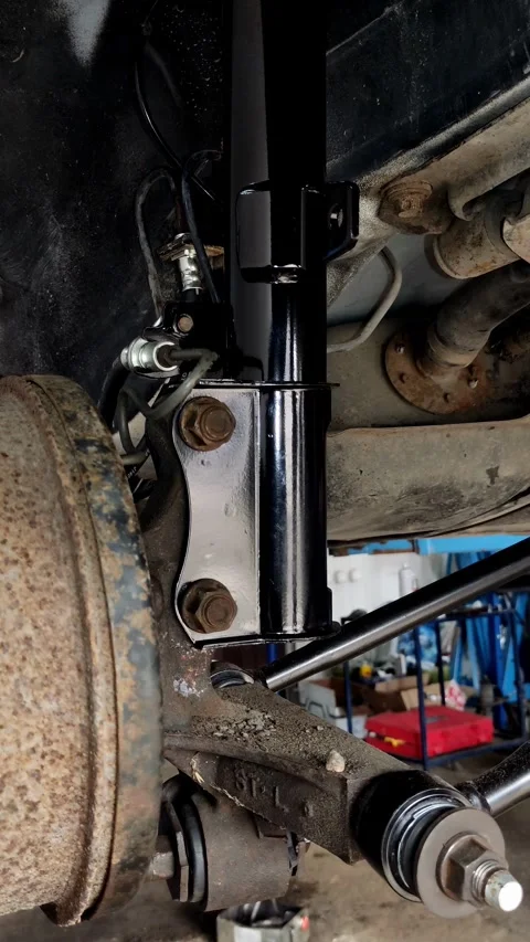 Camera pans slowly over newly installed shiny black car suspension Stock Footage 335834426