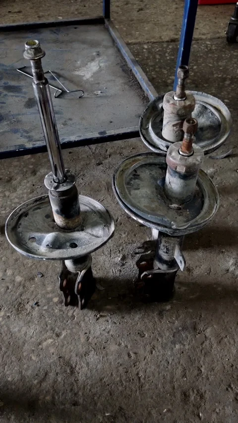 Camera pans slowly over old metallic car struts on ground Stock Footage 335834816