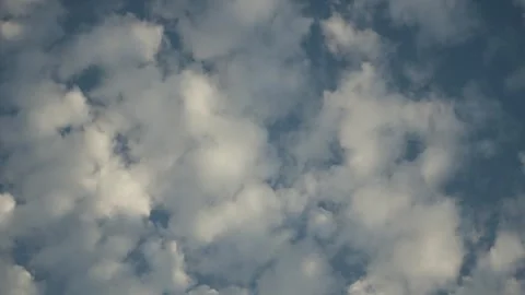 Camera pans softly across bright clouds drifting in blue sky Vídeo Stock 344502991