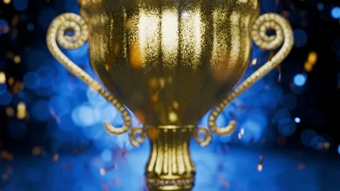 The camera pans upward along the golden cube, showering the golden trophy with Stockbeeldmateriaal 342082277