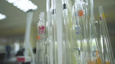 The camera passes around test tubes and tubes stacked on a table in the lab.  Stock Footage 153863316