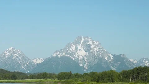 Camera passing Grand Teton mountain with cars in foreground Stock-Footage 79475625