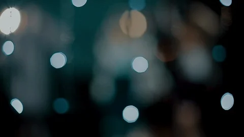 The camera peeps through the glowing lights as young people  rejoice and dance Stock-Footage 114627947