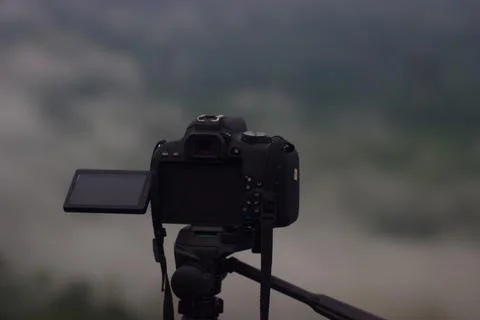 A camera that is placed on a tripod with a natural background Stock Photos