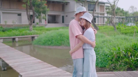 The camera plans to approach the subject. A couple walks in and hugs with warmth Stock Footage 265052523
