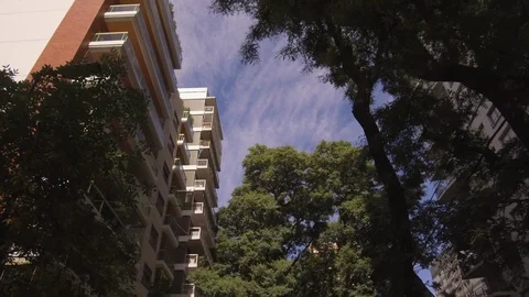 Camera POV flying drone driving low angle over street trees and buildings. Video stock 105691052