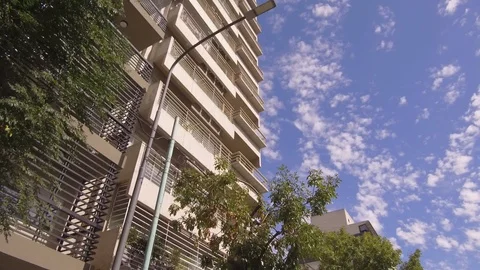 Camera POV flying drone driving low angle over street trees and buildings. Stock Footage 105693421