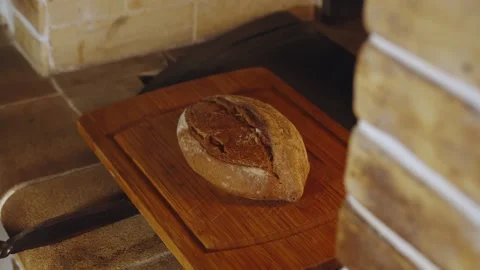 Camera pull focus from rustic bakery stone oven on freshly baked aromatic loaf Stock Footage 279230472