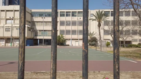 Camera pull out from school to a gate or metal fence - empty school during break Stock Footage 128087465
