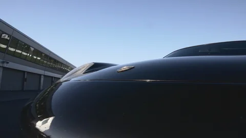 Camera pulling away from a Parked PORCHE  on empty roads. It's a sunny day Video stock 127403448