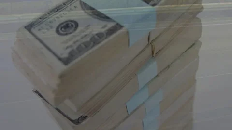 Camera pulling back and focusing, revealing rotating cash stacks and bands for Video stock 334202488