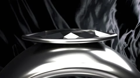 Camera pulling back and tilting, revealing polished ring on black satin drape Stock Footage 339448658