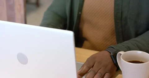 Camera pulling back from dark hands typing on silver laptop for work, revealing Stock Footage 336305663