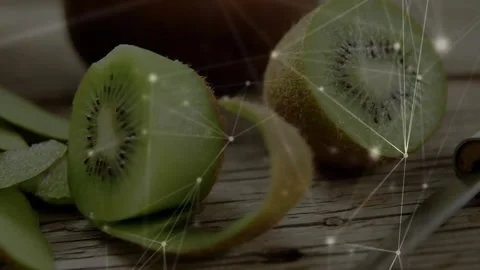 Camera pulling back, halved kiwi rotating, peel curling, slices forming, overlay Stock Footage 330192172