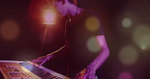 Camera pulling back male keyboardist playing keys adjusting knobs spotlight 库存影片 331269863