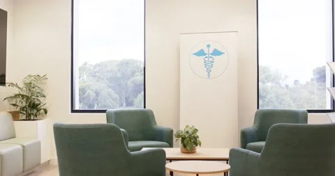 Camera is pulling back in medical waiting room, revealing teal armchairs and Stock Footage 337400185