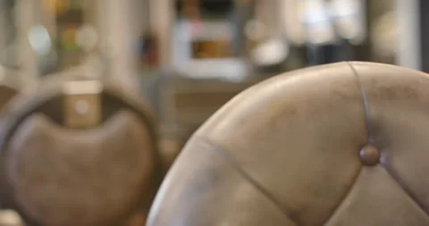 Camera is pulling back, panning and refocusing to reveal brown tufted chair and Stock Footage 339232058