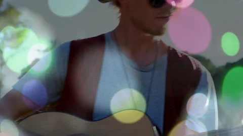 Camera pulling back revealing solo guitarist strumming nylon strings with bokeh Stock Footage 313329209