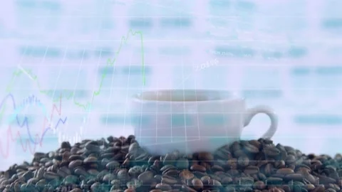 Camera pulling back, revealing white cup on beans, fading finance charts showing Stock Footage 332981486
