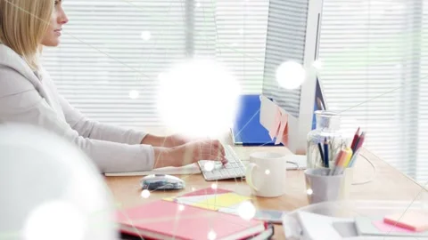 Camera pulling back revealing woman typing on keyboard at office desk, bokeh Video stock 333035137