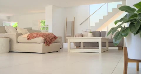 Camera pulling back rising revealing tan sofa table plant and stairs framing Stock Footage 339162771